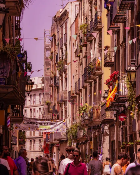 A narrow Barcelona street in the evening, balconies on both sides