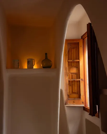 A sunlit window in a whitewashed hallway