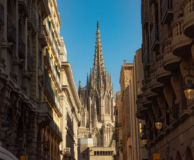 The spire of a cathedral framed by a narrow street