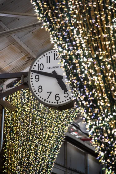 A station clock surrounded by strings of lights