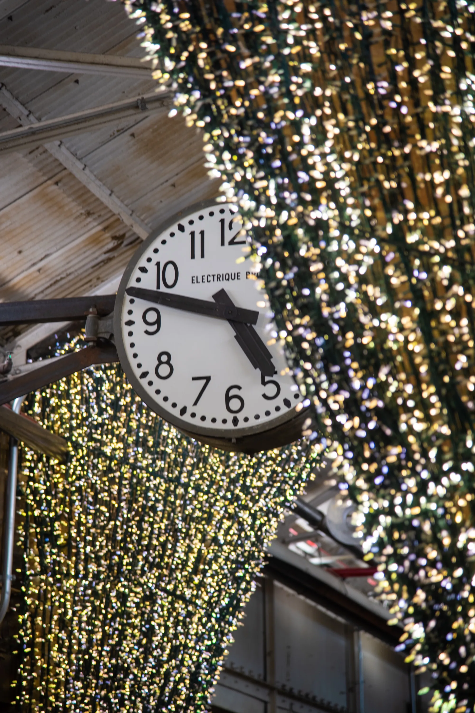 A station clock surrounded by strings of lights